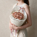 Woman holding the dusty pink Always Yours soap flower bouquet in cream wrap