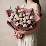 Woman holding the Amour fresh flower bouquet in dusty rose wrap