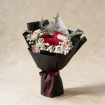Blissful fresh flower bouquet of three red roses with spray carnations, baby’s breath and caspia in black wrap