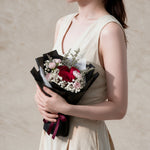 Woman holding the Blissful fresh flower bouquet in black wrap