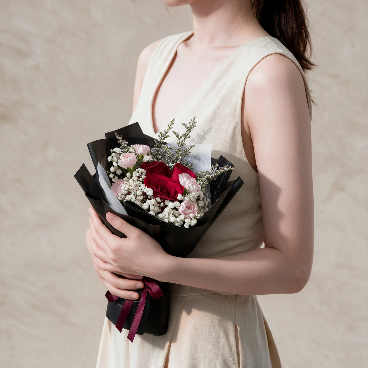 Woman holding the Blissful fresh flower bouquet in black wrap