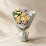 Darling fresh flower bouquet of three peach roses with spray carnations, asters, eustoma and baby’s breath in sage green wrap