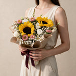 Woman holding the Dreamy Days fresh flower bouquet in kraft paper