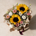 Top view of the Dreamy Days fresh flower bouquet of two sunflowers with pink asters, eustoma and baby’s breath