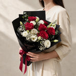 Woman holding the Gentle Kiss fresh flower bouquet in black wrap