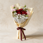 Keepsake fresh flower bouquet of three red roses with spray carnations, eustoma and baby’s breath in cream wrap