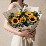 Woman holding the Sunny fresh flower bouquet in cream wrap