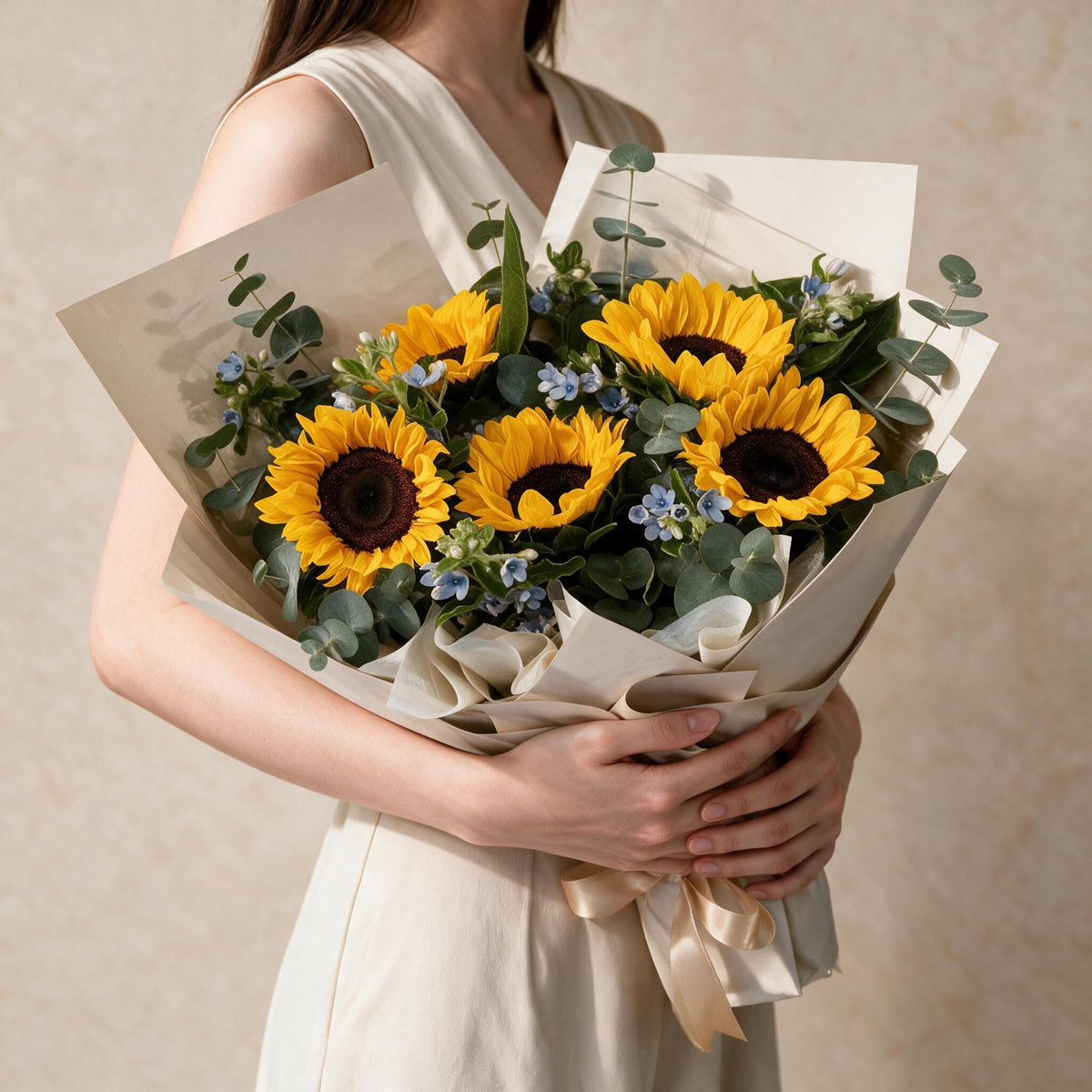 Woman holding the Sunny fresh flower bouquet in cream wrap