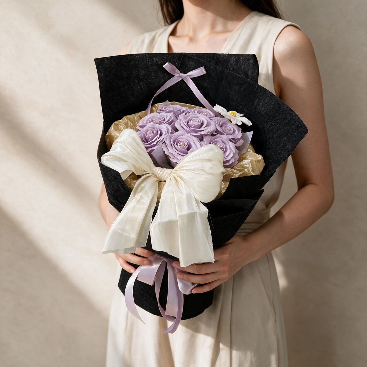 Woman holding the lilac True Affection soap flower bouquet in black and gold wrap