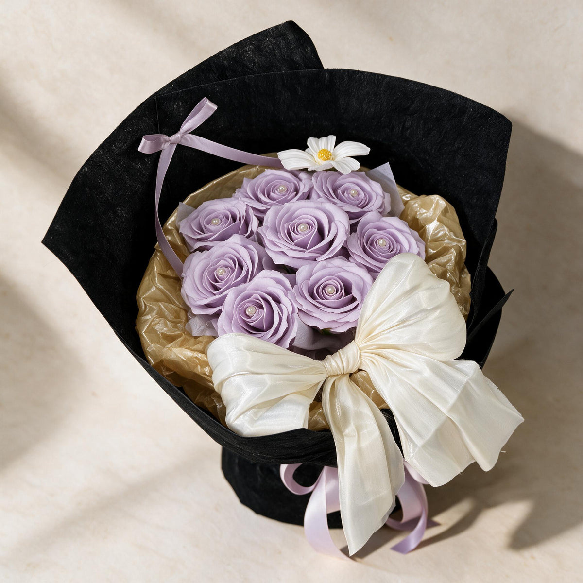 Top view of the True Affection soap flower bouquet of eight lilac roses and a cosmos