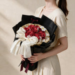 Woman holding the red True Affection soap flower bouquet in black and gold wrap