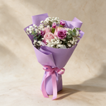Whisper fresh flower bouquet of three pink roses with spray carnations, baby’s breath and eucalyptus in lilac wrap