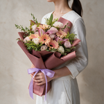 Woman holding the Belle fresh flower bouquet of peach gerberas