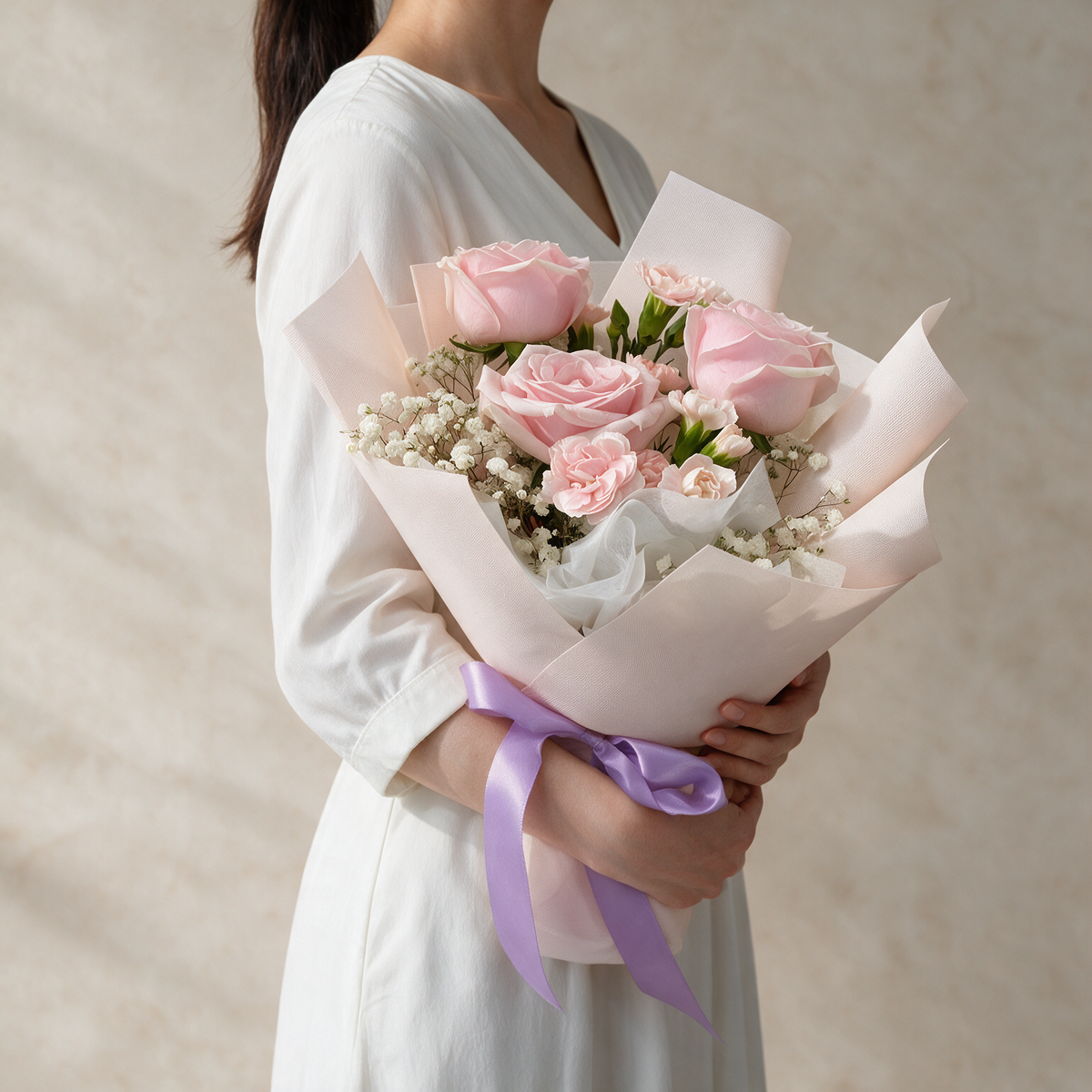 Woman holding the Blush fresh flower bouquet of pink roses