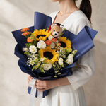 Woman holding the Delight fresh flower graduation bouquet with a Convo Bear