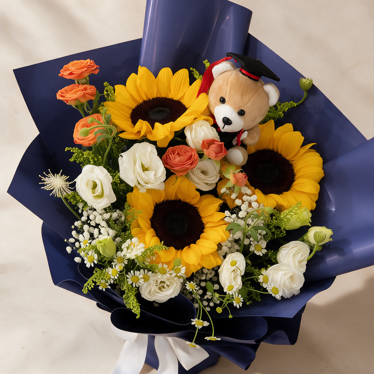Top view of the Delight bouquet of three sunflowers with spray roses, mini daisies and a Convo Bear