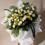 Close-up of the Everlasting condolence flower stand of white roses and yellow cymbidium orchids