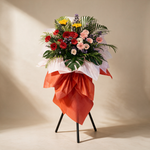 Fortune grand opening flower stand of red, pink and white gerbera daisies with sunflowers and purple peacock