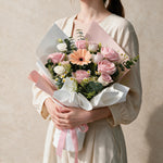 Woman holding the Love Story fresh flower bouquet in white and pink wrap