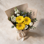 Top view of the Next Chapter bouquet of yellow gerberas and blue oxy