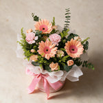 Top view of the Serendipity fresh flower bouquet of three peach daisies with spray carnations, yellow peacock and eucalyptus