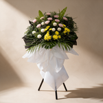 Solace condolence flower stand of white ping pong chrysanthemums, pink mums and yellow pom chrysanthemums