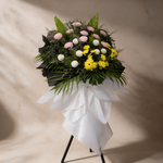 Side view of the Solace funeral flower stand of chrysanthemums