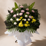 Close-up of the Solace condolence flower stand of white, pink and yellow chrysanthemums