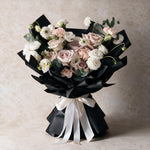 Sweet Embrace fresh flower bouquet of six dusty pink roses with carnations, eustoma, scabiosa and eucalyptus in black wrap