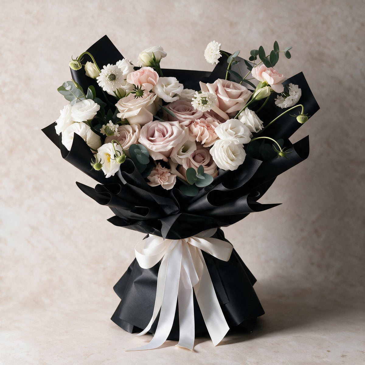 Sweet Embrace fresh flower bouquet of six dusty pink roses with carnations, eustoma, scabiosa and eucalyptus in black wrap