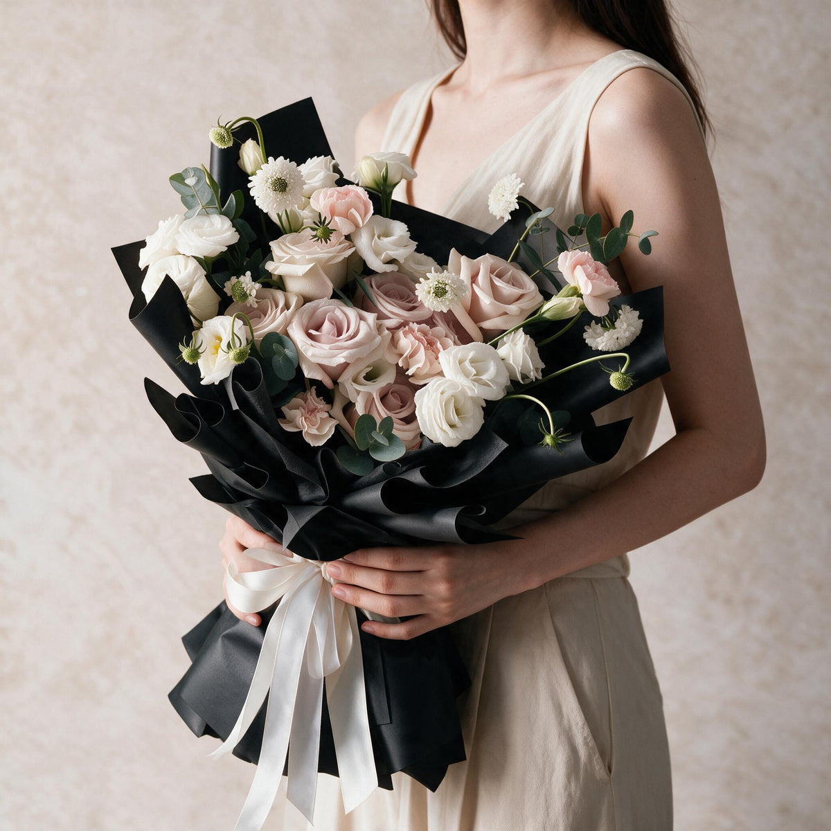Woman holding the Sweet Embrace fresh flower bouquet in black wrap