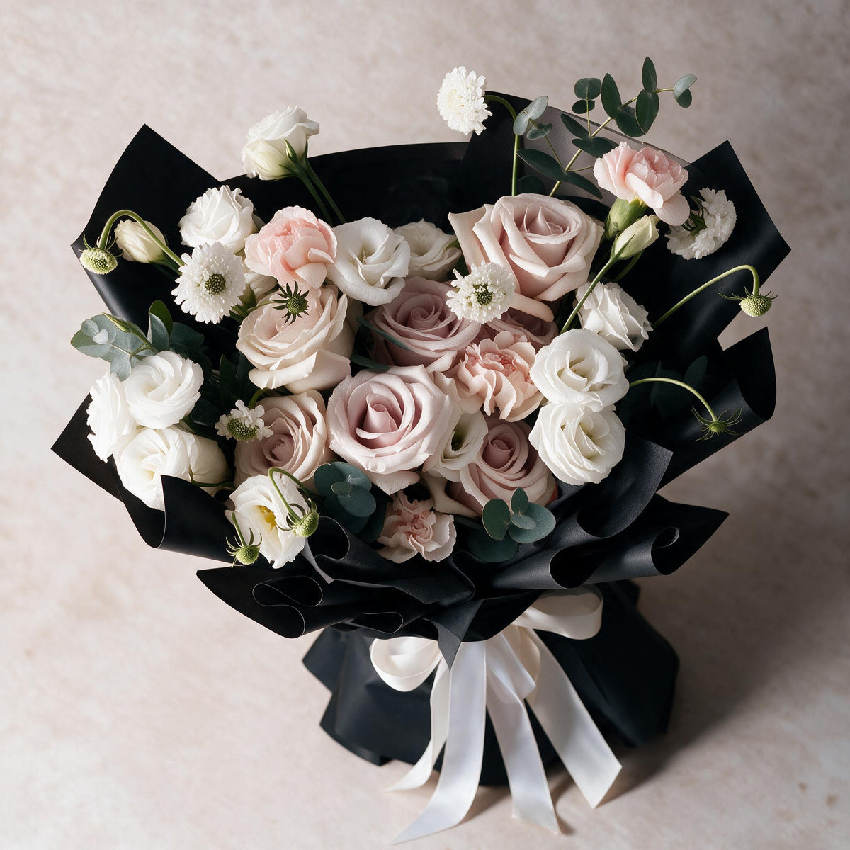 Top view of the Sweet Embrace fresh flower bouquet of six dusty pink roses with carnations, eustoma, scabiosa and eucalyptus