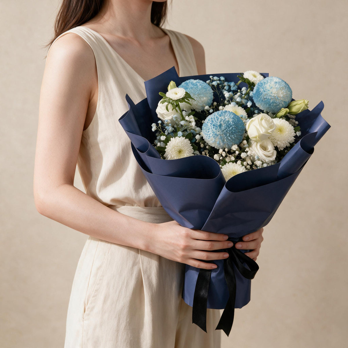 Woman holding the Tender Love fresh flower bouquet in navy wrap