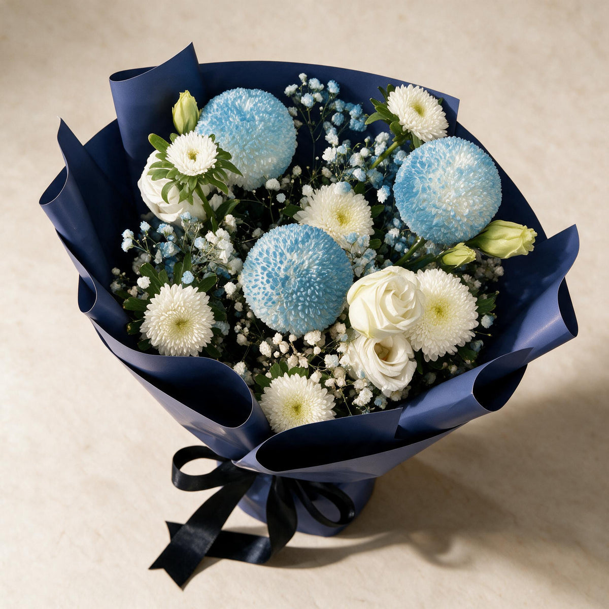 Top view of the Tender Love fresh flower bouquet of three blue pingpong chrysanthemums with asters, eustoma and baby’s breath